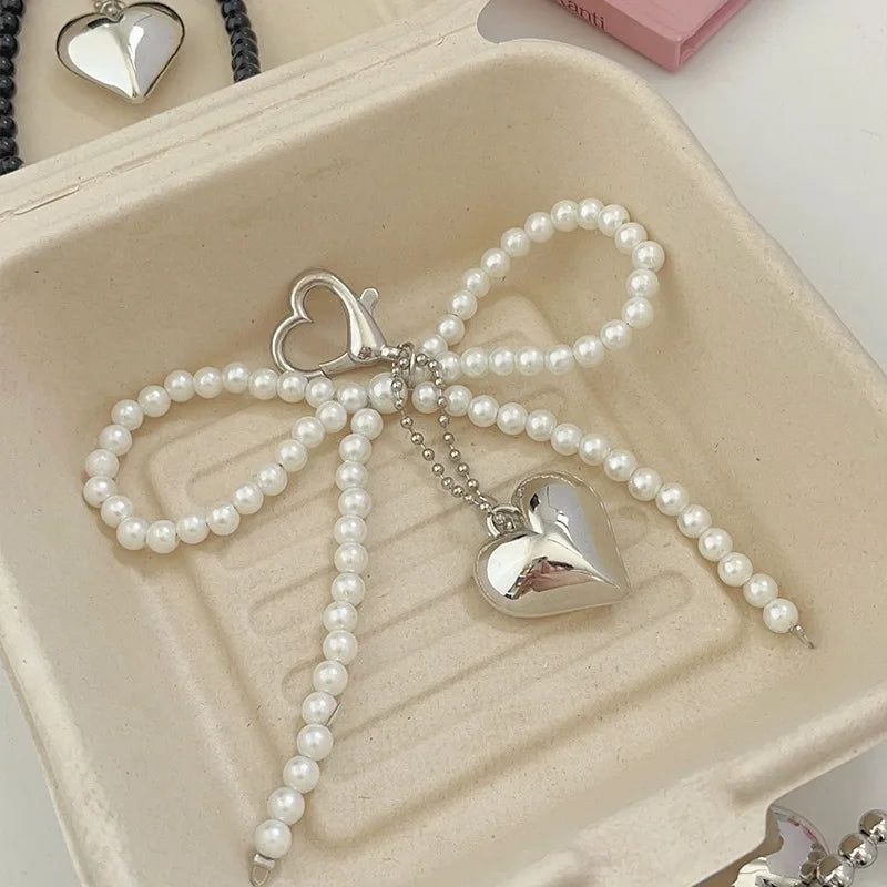 ميدالية مفاتيح زاكول بيضاء على شكل قلب وربطة فيونكة للنساء، سحر لطيف من اللؤلؤ، حلقة مفاتيح للحقائب الظهرية، مجوهرات يدوية الصنع، زينة معلقة للحقائب، هدية